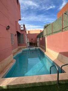 a swimming pool in the side of a building at Villa ETAHIRI in Marrakesh