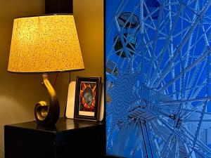 a lamp on a table with a picture and a painting at Spin Inn in Kotor