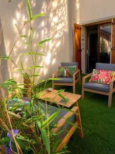 a patio with two chairs and a wooden table at ROOMS HOME CSM Suites privees élégantes entre Reims et Disneyland Paris 1 à 8 personnes in Charly-sur-Marne