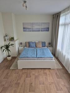 a bedroom with a bed with blue sheets and wood floors at Ferienwohnung Einfeld in Neumünster