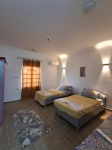a room with two beds and a window at El Agamy Hotel Apartment in Luxor