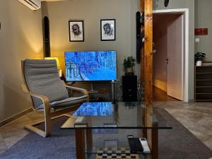a living room with a chair and a television at Spin Inn in Kotor