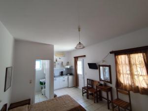 a living room with a table and a kitchen at Areti studios in Vathi +14 photos