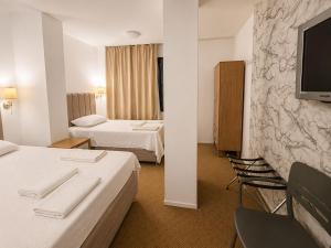 a hotel room with two beds and a flat screen tv at çayır butik otel in Marmaraereglisi +77 photos
