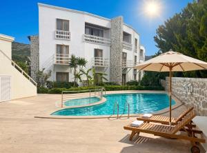 a villa with a swimming pool and an umbrella at Mercans Bodrum Beach Hotel in Bodrum City