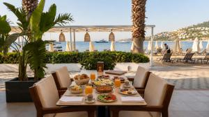 a table with food on it with a view of the beach at Mercans Bodrum Beach Hotel in Bodrum City