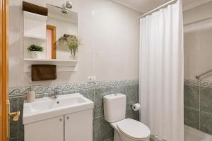 a bathroom with a white toilet and a sink at Ganivet Home in Arrecife +18 photos