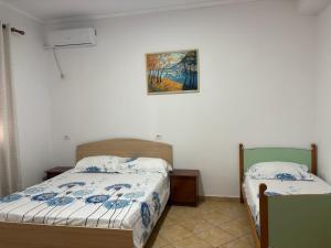 a bedroom with two beds and a picture on the wall at Vila Brahimasi in Durrës