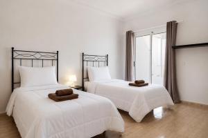 a bedroom with two beds with towels on them at Ganivet Home in Arrecife
