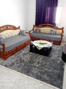 a living room with two couches and a coffee table at Dar MORTADA TATAOUINE in Tataouine