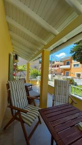 a patio with two chairs and a wooden table at Kipos Apartments in Kassiopi
