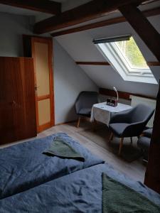 a bedroom with a bed and a table and a window at Penzion Jakuby in Děčín
