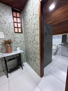 a bathroom with a toilet and a table and a door at Casa Astral in Chapada dos Guimarães