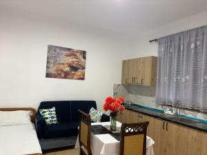 a living room with a couch and a table with flowers at Vila Brahimasi in Durrës