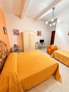 a bedroom with two beds and an orange couch at B&B A Vinedda in Scilla