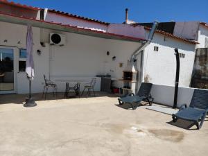a patio with chairs and a table and a building at A Casinha in Portel