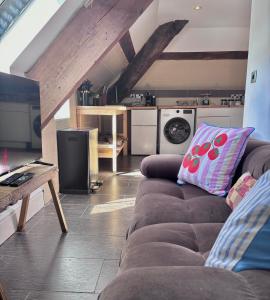 a living room with a couch and a kitchen at The Eaves - Pen Y Fan Views in Brecon