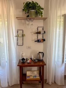 a table with a plant on a wall with curtains at Nima in Porto Santo Stefano