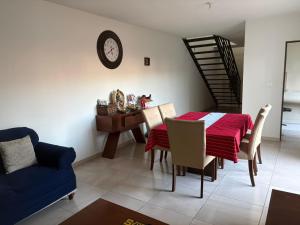 a dining room with a table and chairs and a clock at Casa en zona industrial SLP in San Luis Potosí
