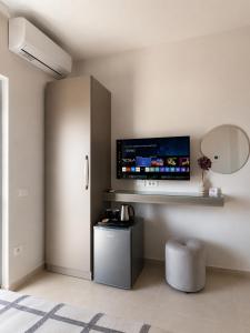 a room with a flat screen tv on a wall at Nostos Palase in Dhërmi