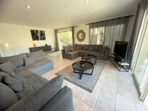 a living room with a couch and a table at Villa Arethuse - Pyla sur Mer in Pyla-sur-Mer