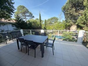 a black table and chairs sitting on a patio at Villa Arethuse - Pyla sur Mer in Pyla-sur-Mer