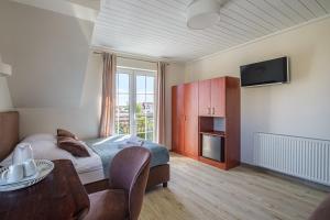 a bedroom with a bed and a table and a tv at Villa Baltica in Łeba