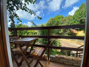 a porch with a wooden table and chairs on it at Kailua apartamentos e suítes in Porto De Galinhas