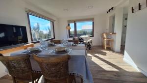 a dining room with a table and some windows at Jardín de Estepa in Dina Huapi