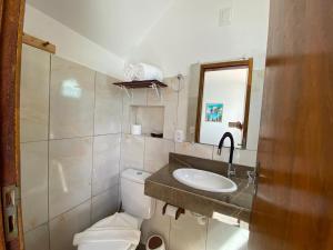 a bathroom with a toilet and a sink and a mirror at Kailua apartamentos e suítes in Porto De Galinhas +51 photos