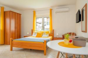 a bedroom with a bed and a white table at Apartmani Aleks in Budva