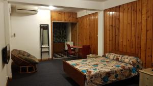 a bedroom with a bed and a table with a chair at Rittoo Complex -Gavnor in Quatre Bornes