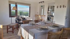 a dining room with a table with plates and glasses at Jardín de Estepa in Dina Huapi +10 photos