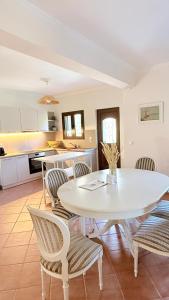 a kitchen and dining room with a white table and chairs at Casa SanGiorgio Stone Villas with Sea View in Skaltsotiánika