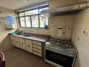 a kitchen with a stove and a sink at Casa Bella Itaúna Suites in Saquarema