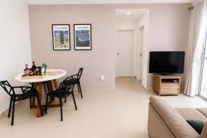 a living room with a table and a tv at Ap Go travel in São Luís