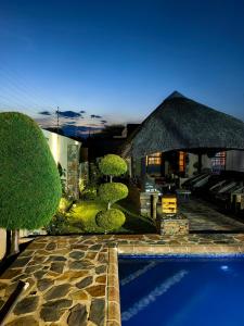 a villa with a swimming pool and a house at Mukani B&B in Lobatse