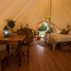 a bedroom with a bed and a table in a tent at Near The City Tent in Sainte-Catherine