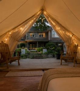 a tent with two chairs in front of a house at Near The City Tent in Sainte-Catherine