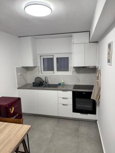 a kitchen with white cabinets and a black oven at Hera in Verga Kalamata