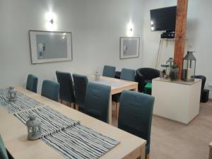une salle de conférence avec des tables et des chaises et une télévision dans l'établissement Fachwerkresidenz Deuterscher Hof, à Quedlinbourg