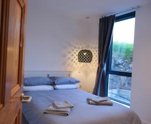 a bedroom with a bed with two towels on it at Pheasants Call in Kenmare