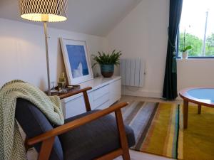 a living room with a chair and a table at Pheasants Call in Kenmare +20 photos