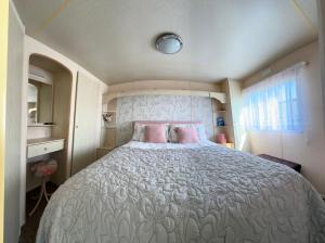 a bedroom with a large bed with pink pillows at Klara Happy Days in Trusthorpe