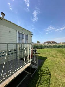 a mobile home with a deck and a yard at Klara Happy Days in Trusthorpe +9 photos