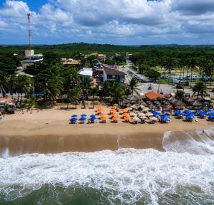 an aerial view of a beach with chairs and umbrellas at Pousada Recanto Paradise in Porto De Galinhas