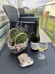 a table with a bottle of wine and a basket of flowers at Klara Happy Days in Trusthorpe