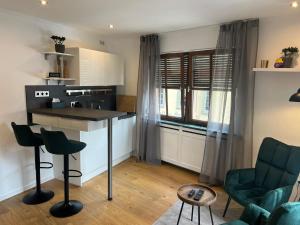 a kitchen with a counter and chairs in a room at Altstadtappartment Plötze 13 Limburg in Limburg an der Lahn