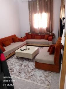 a living room with two couches and a coffee table at Dar MORTADA TATAOUINE in Tataouine