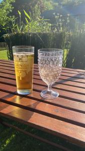 a drink and a glass on a wooden table at Cedar Lodge in Torpoint
